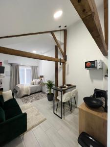 a living room with a green couch and a bed at SUITES CHIC in Herencia