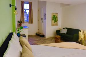 Boetiek hotel Azul في Goedereede: غرفة معيشة مع سرير وأريكة