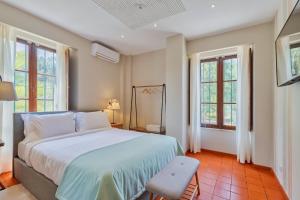 a bedroom with a large bed and two windows at Villa Casal Assis in Setúbal