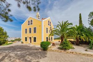 a yellow building with a tower on top of it at Villa Casal Assis in Setúbal