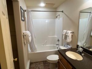 uma casa de banho com um chuveiro, um WC e um lavatório. em Faithful Street Inn em West Yellowstone