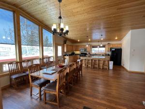 a dining room with a table and chairs and a kitchen at Faithful Street Inn in West Yellowstone