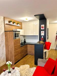 a kitchen with red pillows and a red couch in a room at Downtown Apartments Presley air-conditioned in Rzeszów