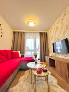 a living room with a red couch and a table at Downtown Apartments Presley air-conditioned in Rzeszów
