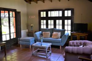 sala de estar con sofá azul y TV en Casa Del Molino, Casa de Campo, Cañuelas en Cañuelas
