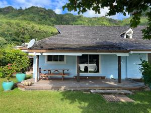 a blue house with a picnic table on a deck at Villa Ohana - Deluxe Villa w Private Beachfront in Otumai
