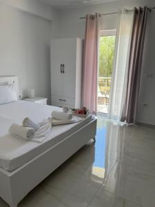 a bedroom with a bed and a large window at Villa Angelina Ksamil in Ksamil