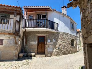 an old stone house with a balcony and a door at Vita Portucale ! Countryside Cottage Gem Moncorvo in Torre de Moncorvo