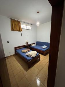 アグアス・ダ・プラタにあるCasa de Campo do Caminho da Féのベッド2台と窓が備わる客室です。