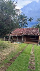 una casa con techo rojo en un patio en Casa de Campo do Caminho da Fé en Águas da Prata