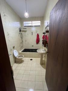 a bathroom with a toilet and a sink and a tub at Casa de Campo do Caminho da Fé in Águas da Prata
