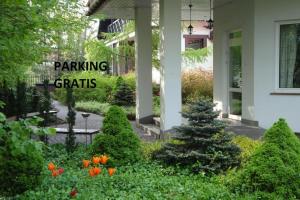 a house with a garden with flowers and plants at Hotel Flora in Łódź