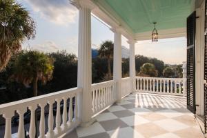 um alpendre de uma casa com um corrimão branco em 20 South Battery em Charleston