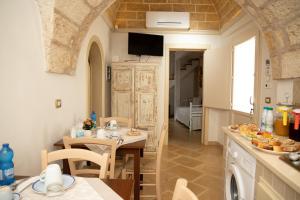 une cuisine et une salle à manger avec une table et des chaises dans l'établissement La Corte dei Sogni, à Taviano 49 autres photos