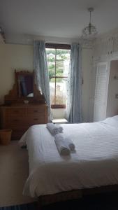 1 dormitorio con 1 cama con toallas en Stunning house with sea views and parking, Newlyn Penzance en Penzance