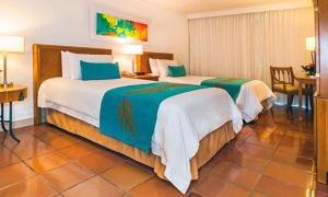 a hotel room with two beds and a table at Hotel Almirante Cartagena Colombia in Cartagena de Indias