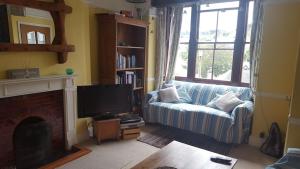 sala de estar con sofá y TV en Stunning house with sea views and parking, Newlyn Penzance en Penzance