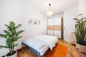 a bedroom with a bed and a potted plant at Metro Bemowo Colourful Apartment in Warsaw