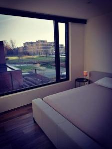 een slaapkamer met een wit bed en een groot raam bij Maison comfortzone met jacuzzi 