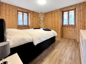 ein Schlafzimmer mit Holzwänden und einem großen Bett in der Unterkunft The Rock House in Sion
