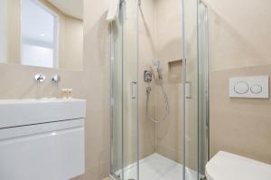 a bathroom with a shower with a toilet and a sink at West Hampstead Serviced Apartments by Concept Apartments in London