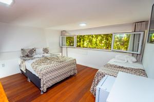 2 Betten in einem Zimmer mit 2 Fenstern in der Unterkunft Brisa do Mar Praia Hotel in Morro de São Paulo