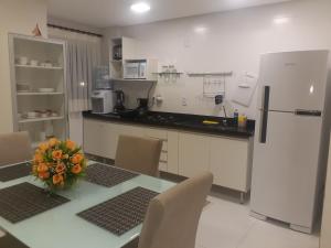 a kitchen with a table with a vase of flowers on it at Lençóis Confort Barreirinhas in Barreirinhas