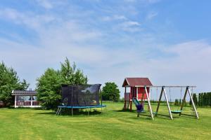 a park with two swings and a gazebo at Villa Ievyne 2 in Paežeriai