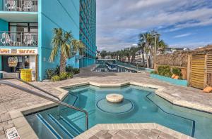a swimming pool in front of a building at Oceanfront Myrtle Beach Condo with Balcony! in Myrtle Beach