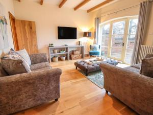 a living room with two couches and a tv at High Trees in Sandbach