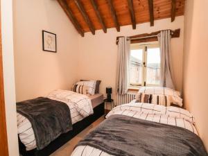 2 camas individuales en una habitación con ventana en High Trees, en Sandbach