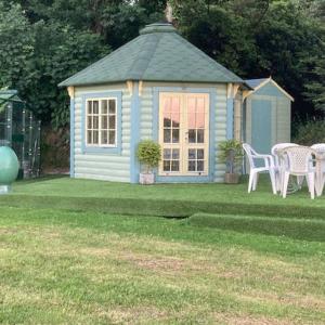 a blue house with chairs and a table in a yard at The Old Deer House in Bodmin