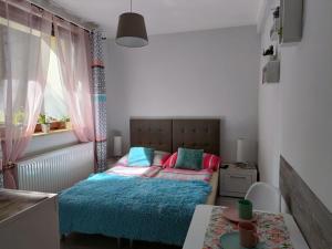 Dormitorio pequeño con cama y mesa en DOMEK Zielona Oaza, en Polanica-Zdrój