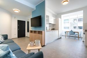 a living room with a couch and a tv and a table at Sapphire Apartment In The Center Of Bucharest in Bucharest