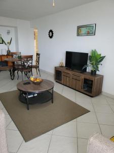 a living room with a coffee table and a flat screen tv at 1B Hastings Towers in Bridgetown