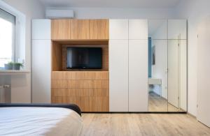 a bedroom with a tv and a sliding glass door at Sapphire Apartment In The Center Of Bucharest in Bucharest