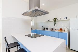uma cozinha com armários azuis e uma bancada em DORA'S HOME em Cacilhas