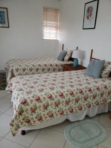 a bedroom with two beds with a floral bedspread at 1B Hastings Towers in Bridgetown
