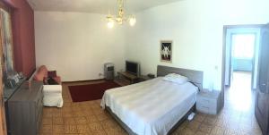 Un dormitorio con una cama grande y una lámpara de araña. en Casa Carolina - Villa/Pool with Bar, 5 bedrooms, 3 bathrooms, Great For Groups., en Castel Rocchero