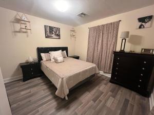 a bedroom with a large bed and a dresser at Simplicity Stays NOLA in New Orleans