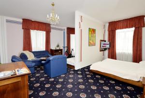 Habitación de hotel con cama y sofá azul en Brioni Boutique Hotel 4* en Ostrava