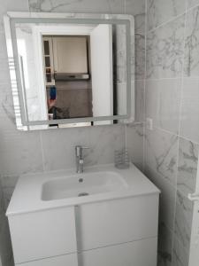 y baño con lavabo blanco y espejo. en studio guéthary - 100 m plages et centre a pieds, en Guéthary