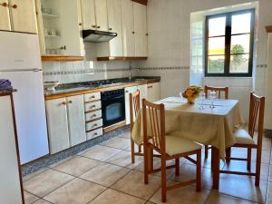 LouroにあるCasa do Campo Louroのキッチン(テーブル、椅子、白い冷蔵庫付)