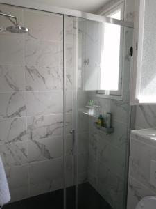 baño con ducha y puerta de cristal en studio guéthary - 100 m plages et centre a pieds, en Guéthary