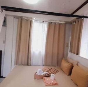 a bedroom with a bed and a window with two towels at De Hagan Transient Baguio City in Baguio