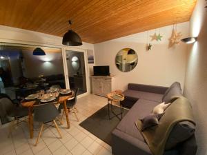 salon z kanapą i stołem w obiekcie Gérardmer Appt 4/6 rez de jardin w mieście Gérardmer