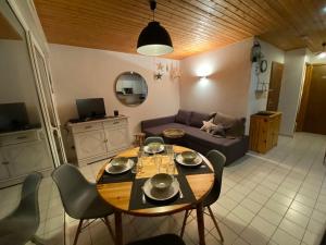 salon ze stołem i kanapą w obiekcie Gérardmer Appt 4/6 rez de jardin w mieście Gérardmer