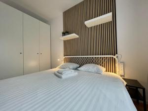 a bedroom with a large white bed with two pillows at Torpo Apartment with parking in Toruń