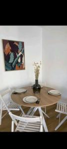 uma mesa de jantar com pratos e um vaso de flores em Coquet logement vu mer à 2 pas des plages em Antibes