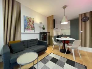 a living room with a couch and a table at Torpo Apartment with parking in Toruń